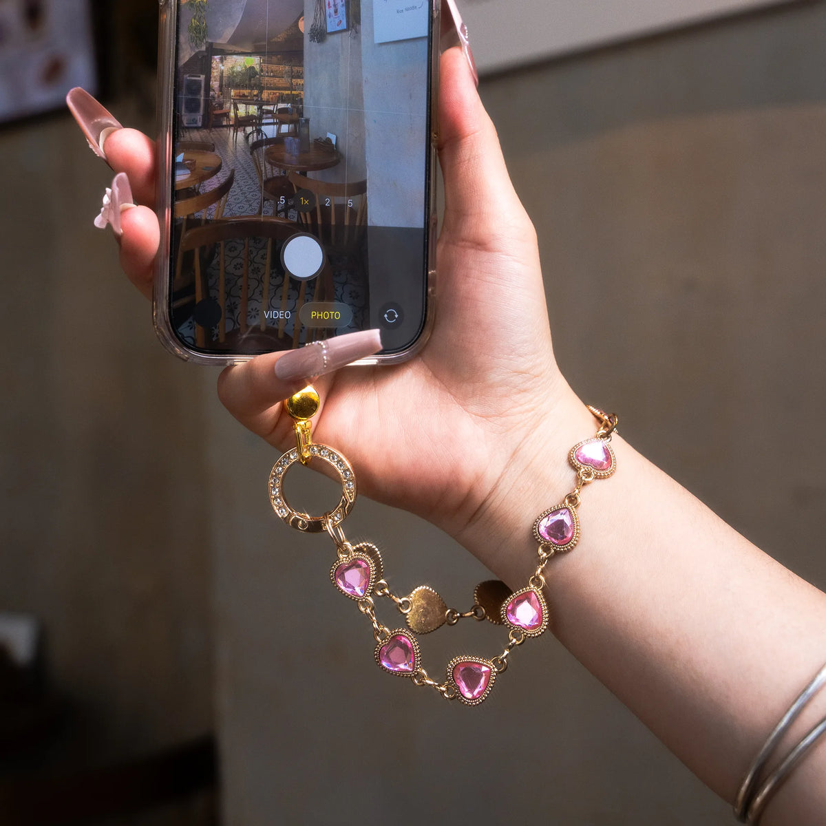 Heartstring charm strap worn on the wrist with phone in hand - all-groups